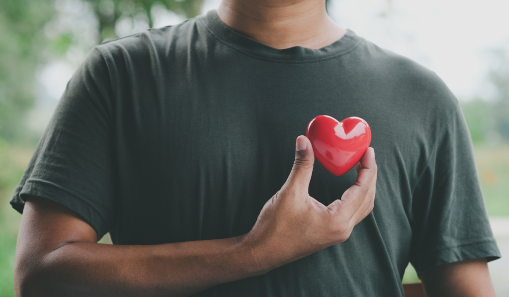 Person holding a red heart to represent heart health during American Heart Month